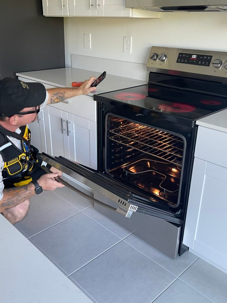 Rob doing a home inspection looking inside of a modern oven in the kitchen